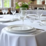 Elegant business lunch setup in a luxury restaurant, pristine white tablecloth with fine china and c