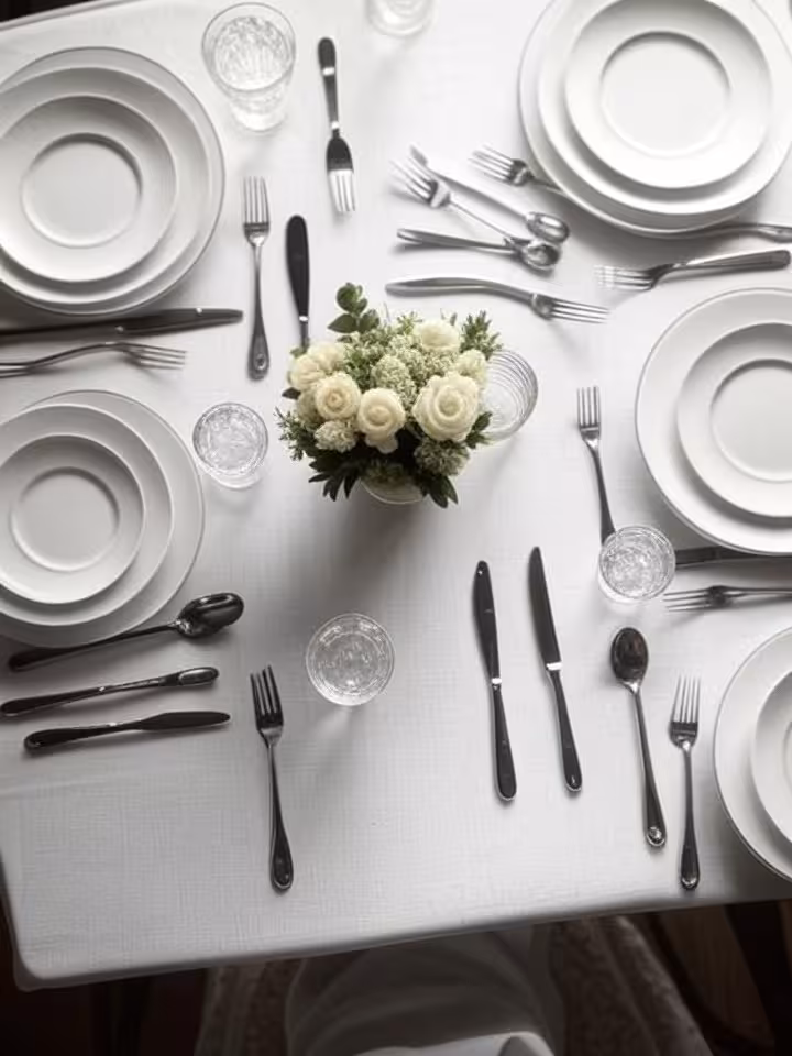 Overhead view of formal dining table setting showing multiple silverware pieces arranged in proper e