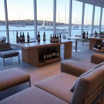 Exclusive wine tasting room in Sydney harbor-view club, floor-to-ceiling windows with sailboat views